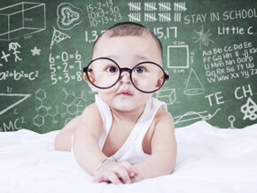 Bebé con gafas mirando la cámara con dibujos de fondo