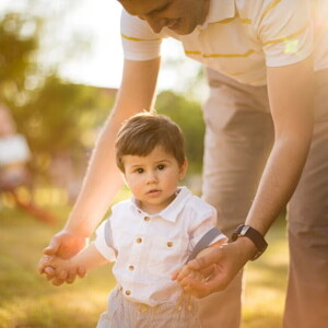 Adulto ayudando a un niño pequeño a caminar.