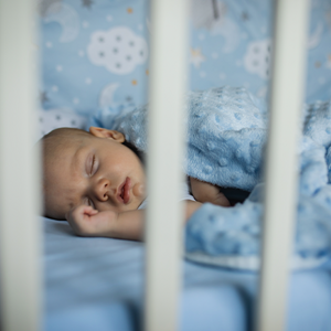 Bebé durmiendo plácidamente en una cuna, con la boca ligeramente abierta.